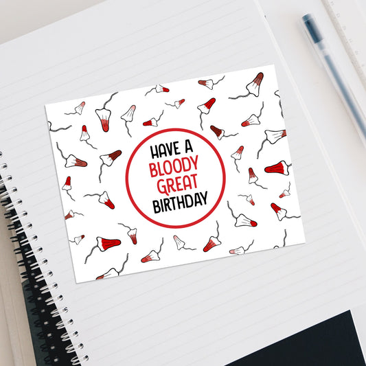 Notebook with a birthday card featuring a red circle and text on a white background