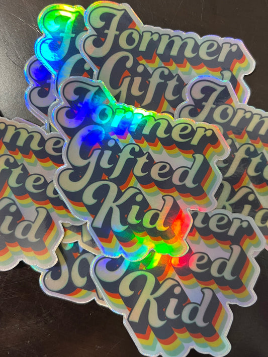 Holographic stickers with 'Former Gifted Kid' text on a dark surface