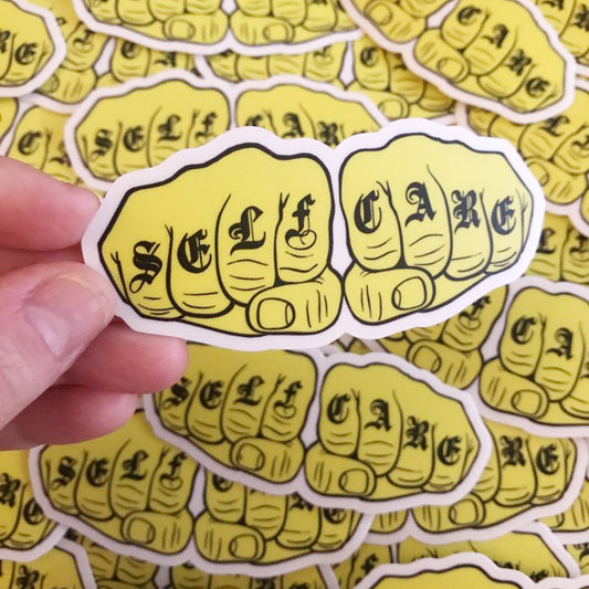 Sticker of a yellow fist with 'SELF CARE' text held over a background of similar stickers.