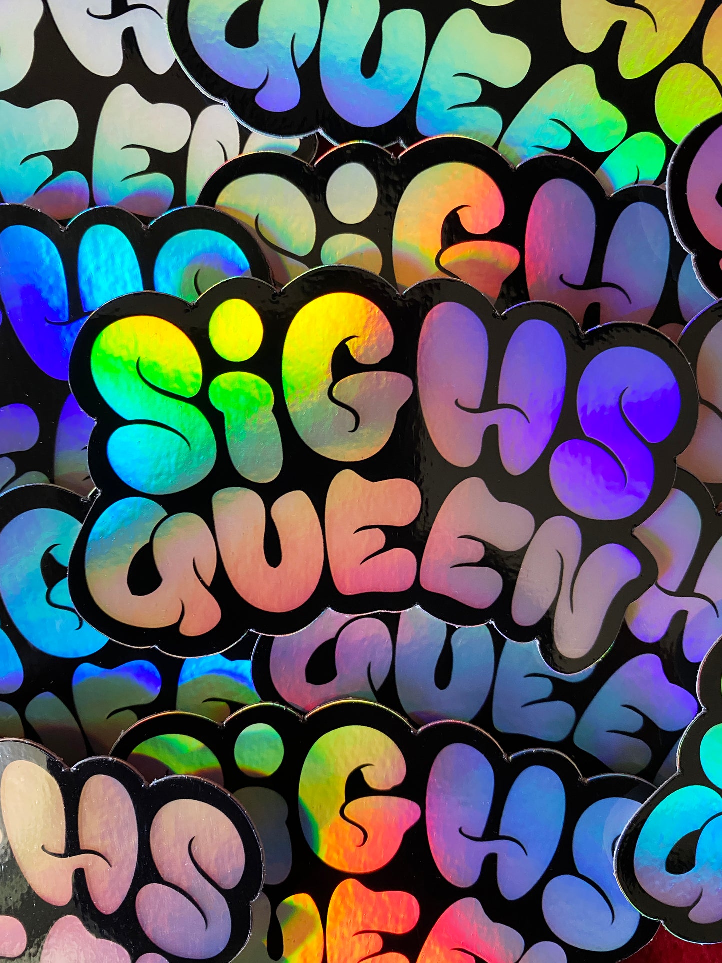 Holographic stickers with 'SIGHS QUEEN' text on a black background